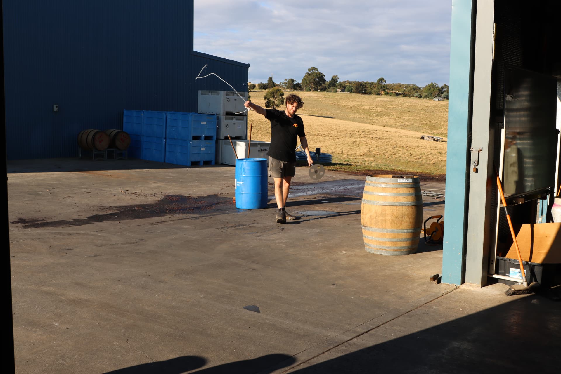 Alex working beside a wine barrel at the winery